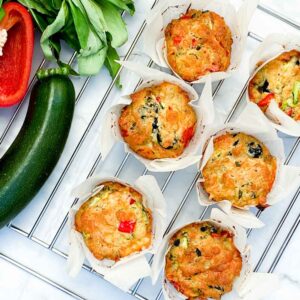 6 cheddar muffins on a tray with vegetables